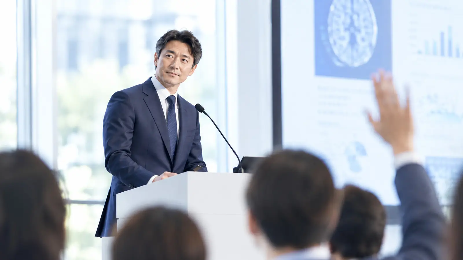 国際学会の会場で、挙手した聴衆からの質問に耳を傾ける日本人医師